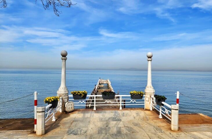 Yürüyen Köşk’ün önündeki beyaz mermer iskeleden denize uzanan huzurlu manzara, mavi gökyüzü ve ufuk çizgisiyle görülüyor.
